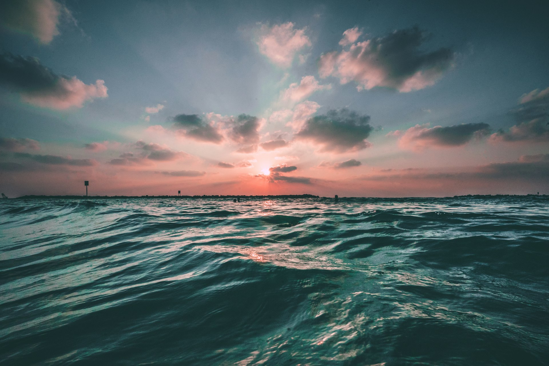 Mar en calma al atardecer, con olas suaves en tonos azul y turquesa